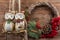 Wreath and two owls figure. Christmas winter frame on dark wooden background. Red elements The inscription in Russian