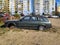 Wreck of old green hatchback car BMW 320 model abandoned