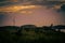 Wrecked abandoned ship on the grass with a windmill in the background at sunset