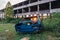 Wrecked car and abandoned ruined industrial building on sunset background