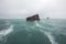 Wrecked cargo ship with conatiners in stormy sea with large waves. Generative AI