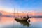 Wrecked fishing boat at sea with sunset in Thailand