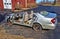 Wrecked silver car in theparking lot of a fire station