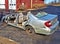 Wrecked silver car in theparking lot of a fire station