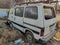 Wrecked white color van, broken and rusty van left in the scrap yard for recycling the van