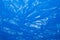 Wrinkled blue plastic sheet for background or text
