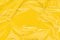 Wrinkled cling film, plastic texture, vinyl yellow art background