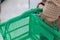 Wrinkled elderly woman`s hand holding shopping basket in shopping mall. Health care, Help, Support, Lifestyle, Senior Workforce,