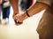 Wrinkled elderly woman`s hand holding to young man`s hand, walking in shopping mall.Family Relation, Health, Help, Support concept