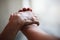 Wrinkled elderly woman`s hand holding to young man`s hand, walking in shopping mall park. Family Relation, Health, Help, Support