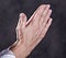 Wrinkly hands of elderly woman praying