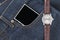 Wrist watch and smartphone on jeans