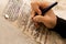 A writer`s hand practices decorating letters from a Torah scroll written on parchment in Hebrew,