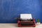 writer's workplace - red typewriter on blue blackboard background