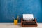 writer's workplace - typewriter and stationery on blue blackboard background