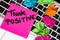 Writing on colorful sticky note Think positive. Text with Think positive on paper. Sticky note, post it and crumpled paper on