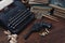 Writing a crime fiction story - old retro vintage typewriter and revolver gun with ammunitions, books, papers, old ink pen