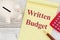 Writing down your budget with a piggy bank, notepad, pen and calculator