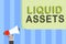 Writing note showing Liquid Assets. Business photo showcasing Cash and Bank Balances Market Liquidity Deferred Stock Man holding m