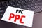 Writing PPC - Pay per Click text made in the office close-up on laptop computer keyboard. Business concept for Internet SEO Money