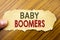 Writing text showing Baby Boomers. Business concept for Demographic Generation written on note paper on the wooden background with