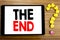 Writing text showing The End. Business concept for End Finish Close written on tablet computer on the wooden background with quest