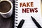 Writing text showing Fake News. Business concept for Hoax Journalism written on notebook book note paper on the wooden wood backgr