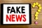 Writing text showing Fake News. Business concept for Hoax Journalism written on tablet computer on the wooden background with ques