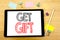 Writing text showing Get Gift. Business concept for Free Shoping Coupon Written on tablet laptop, wooden background with sticky no