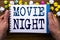 Writing text showing Movie Night. Business concept for Wathing Movies written on notepad notebook book on the wooden wood backgro