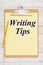 Writing Tips message on yellow lined paper with a pencil on a clipboard