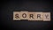 Writing the word Sorry with wooden letters