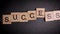 Writing the word Success with wooden letters