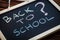Written on the blackboard, Back to School and a question mark. The concept of the school year in the time of the coronavirus pande