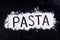 On written flour pasta. Dark background.