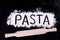 On written flour pasta. Dark background. Rolling pin. On written flour pasta. Broken egg. Spilling pasta.
