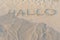 Written words Hallo on sand of beach