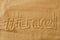 Written words travel with hashtag on sand of beach with wave background