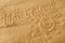 Written words travel with sun sign and beam on sand of beach wave background