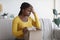 Wrong Package. Upset african american woman sitting with unpacked box at home