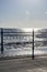 Wrought iron railing at the pier and shadows with sunlight and waves