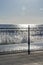 Wrought iron railing at the pier and shadows with sunlight and waves