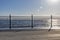 Wrought iron railing at the pier and shadows with sunlight and waves