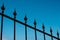 Wrought iron spikes on fence  isolated on sky - railheads