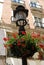 Wrought iron streetlight with pretty geraniums in the city centre, Malaga, Spain.