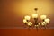 Wrought iron vintage retro chandelier with eight incandescent lamps. Warm yellow light