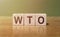 WTO - World Trade Organization acronym written on wooden blocks on wooden table. Concept for your design