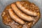 Wurst sausage in onion sauces serving on stone pan. Traditional German food