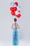 Wwoman wearing beautiful dress with a lot of colorful balloons