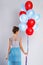 Wwoman wearing beautiful dress with a lot of colorful balloons